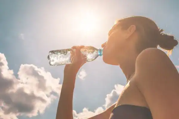 Hydration: The Secret Ingredient for a Toned Stomach and Enhanced Fitness 3 Image of woman drinking water to hydrate Cardiff after run.